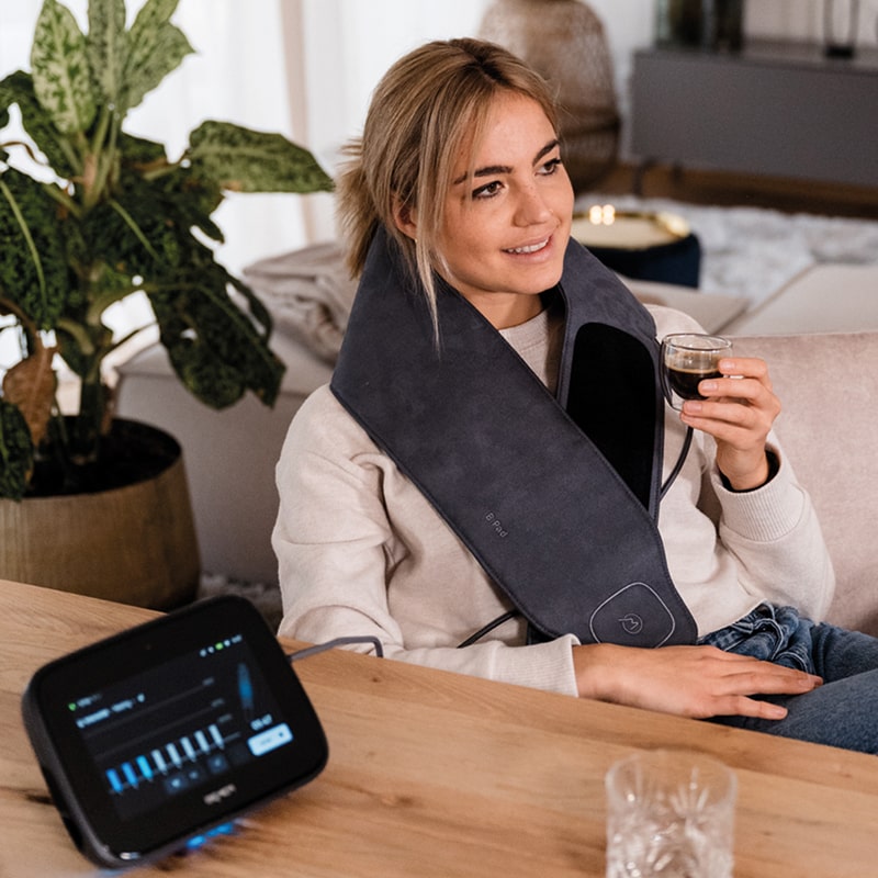 Girl having BEMER therapy at home while sipping a coffee