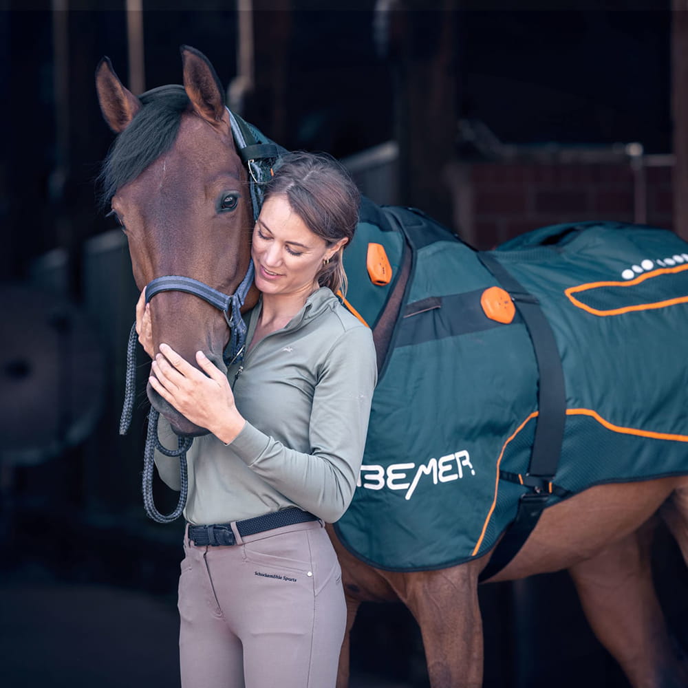 A woman with her horse which is wearing the BEMER Horse-Set